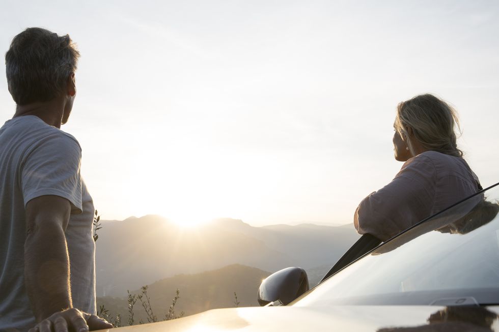 1656862148813033100.jpg couple-stand-by-car-door-look-to-sunrise-hills-royalty-free-image-1652236368.jpg